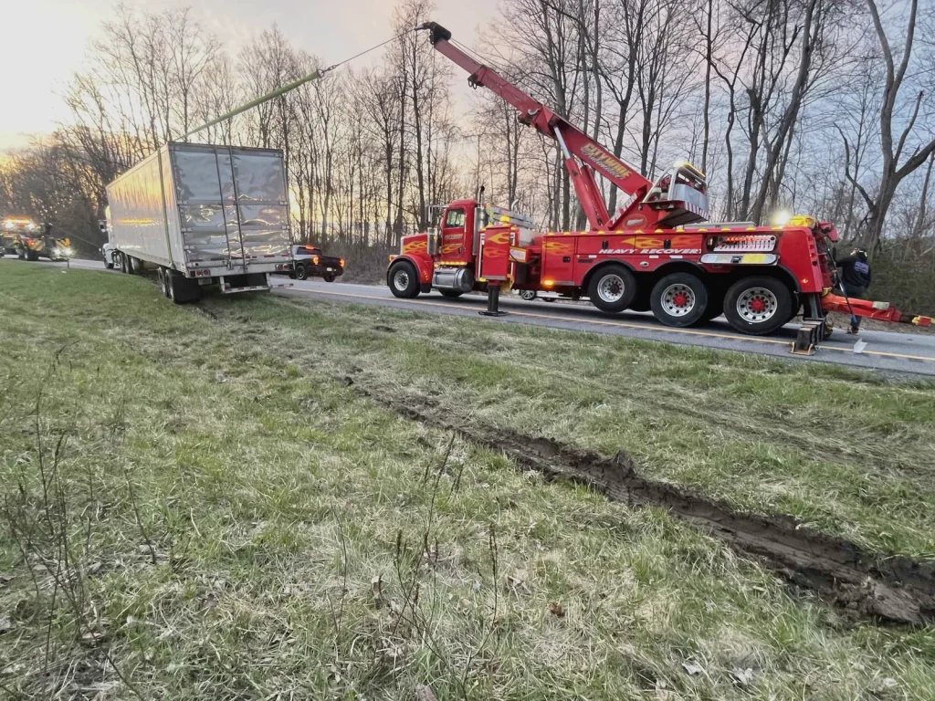 Citywide Automotive heavy recovery wrecker pulling a tractor-trailer out of a ditch at sunset in the Hudson Valley, NY