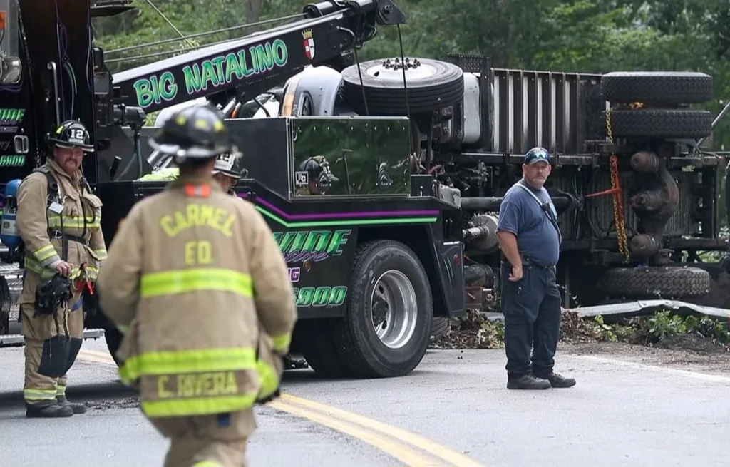 Citywide Big Natalino wrecker alongside Carmel firefighters at an overturned truck recovery