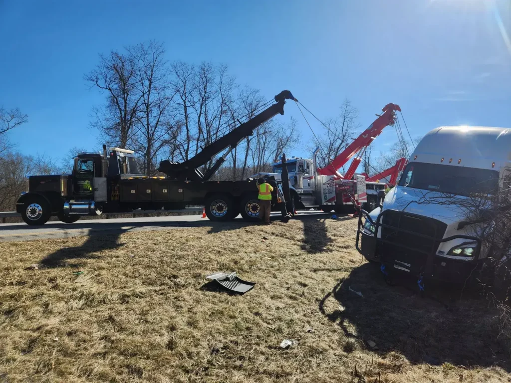 Two heavy-duty wreckers recovering a tractor-trailer from the shoulder in the Hudson Valley, NY